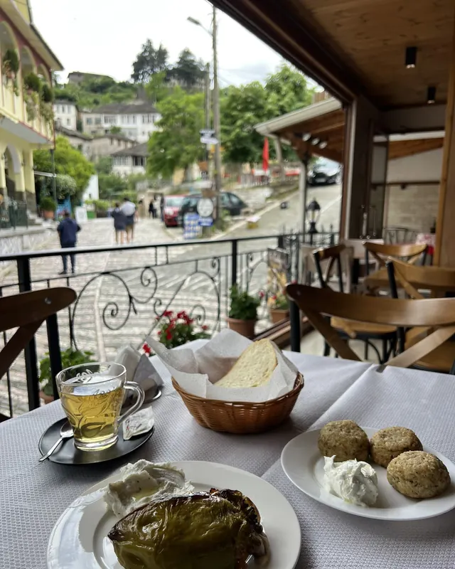Lunch on the covered balcony: stuffed pepper, riceballs and tea, with the cobbled street and stone houses behind